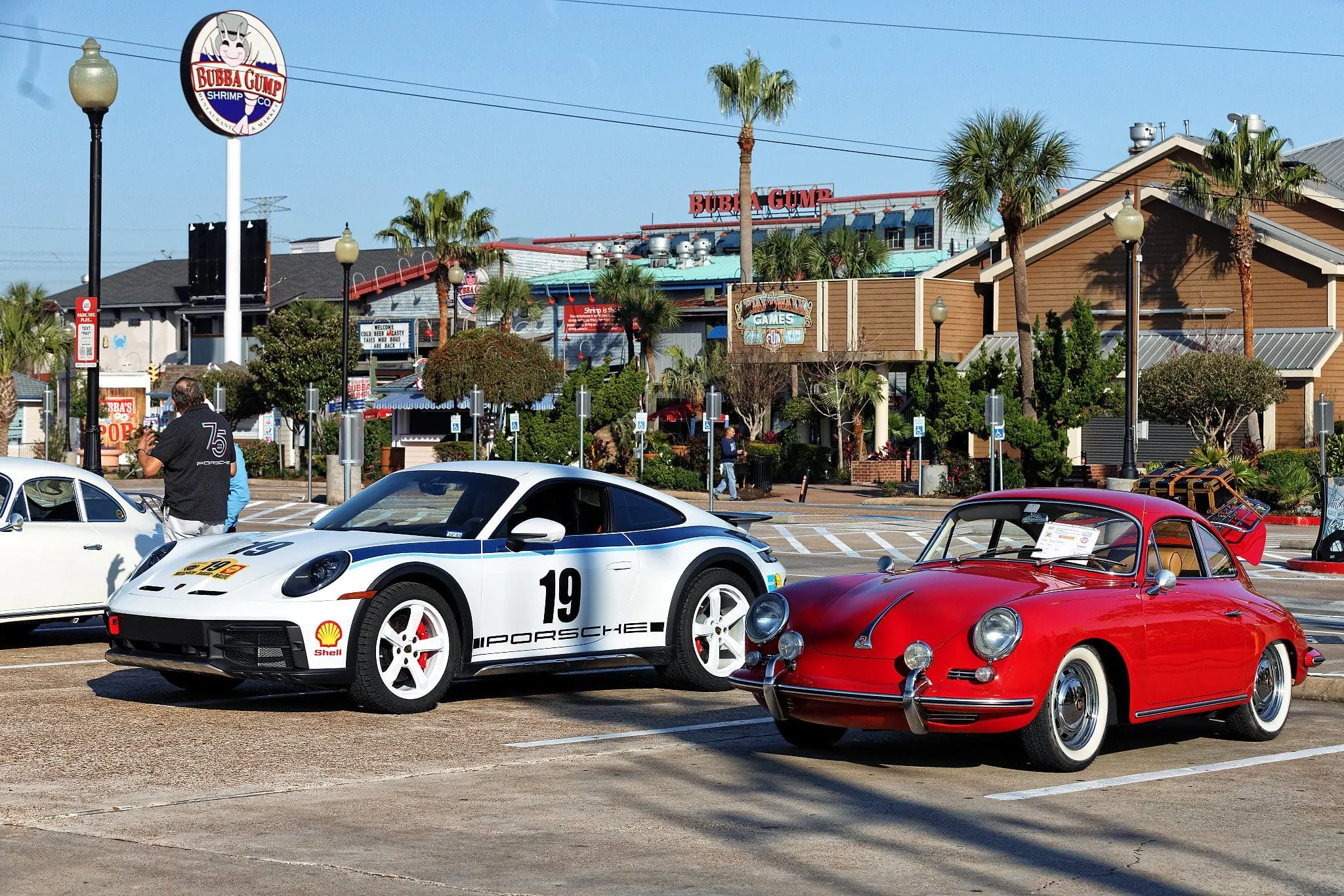 Porsche 911 and classic red sports car parked outdoors at Kemah Concours event.